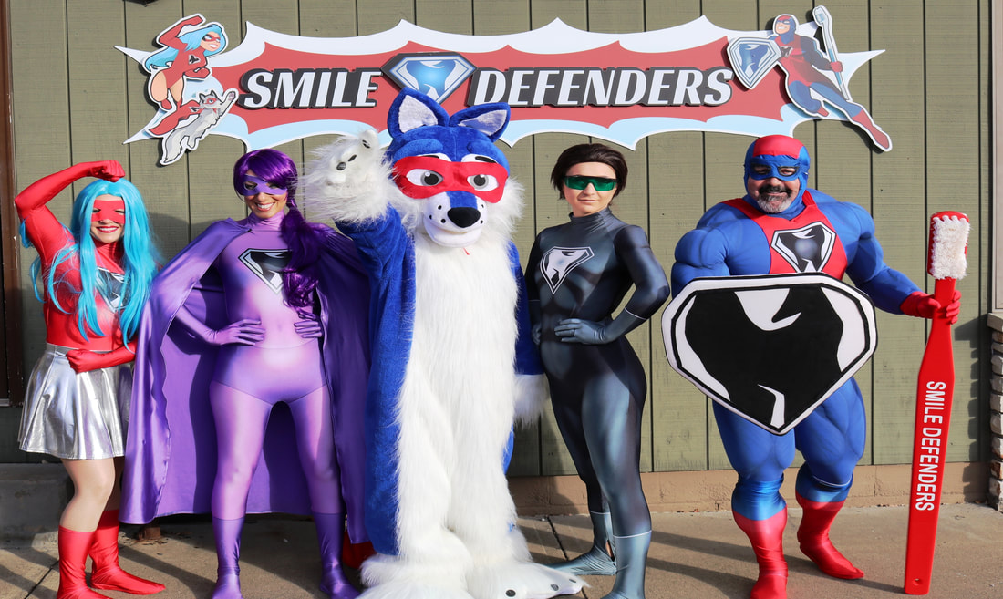 Picture of the Smile Defenders live characters, standing in front of a dental office during their grand opening.